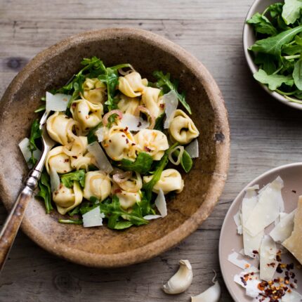 Ensalada de tortellini con rúcula, cebolla y parmesano